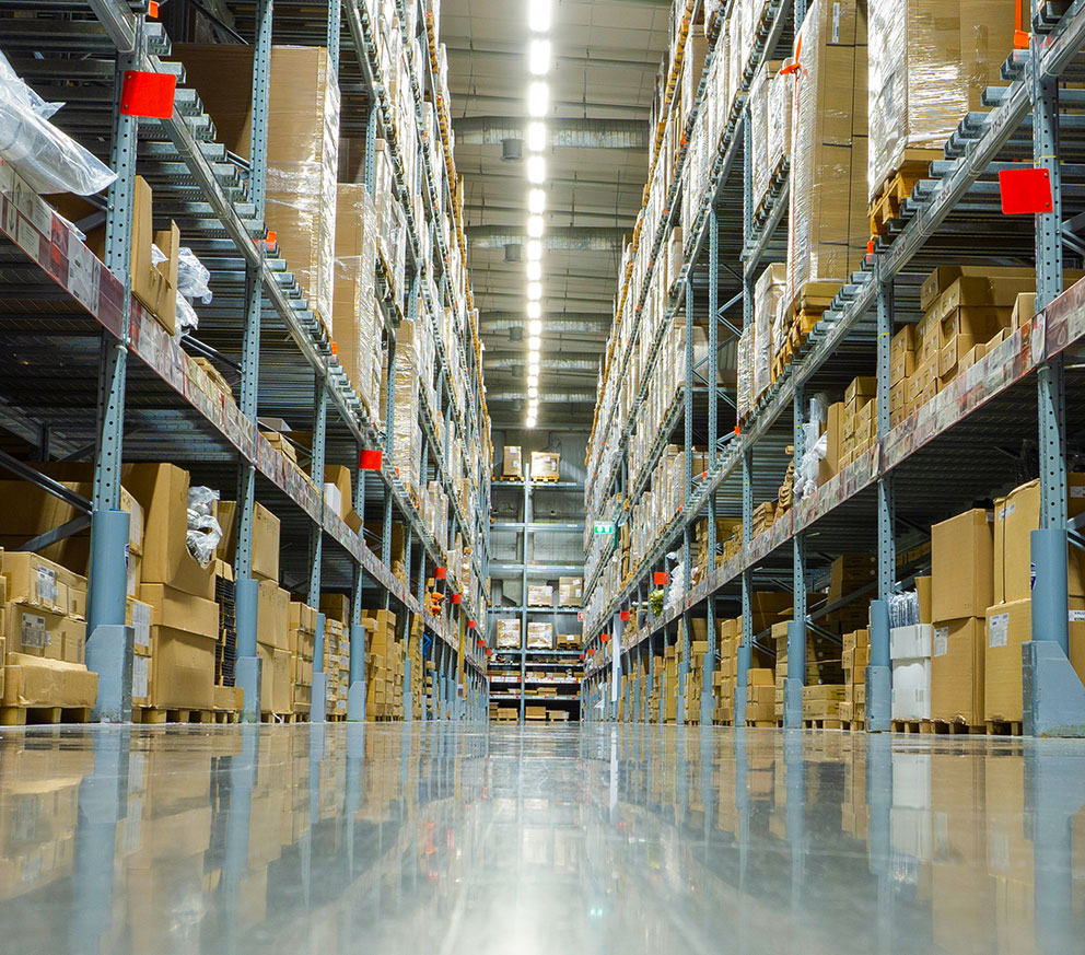 A warehouse with freight on pallets and on the shelves.